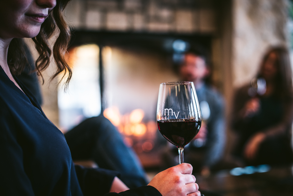 Woman drinking wine by the fire